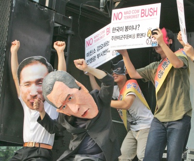 Protestantes sudcoreanos usan mascaras de George W. Bush ay el presidente sudcoreano, Lee Myung-bak, durante las manifestaciones en contra de la visita de Bush a Seúl. (AP)