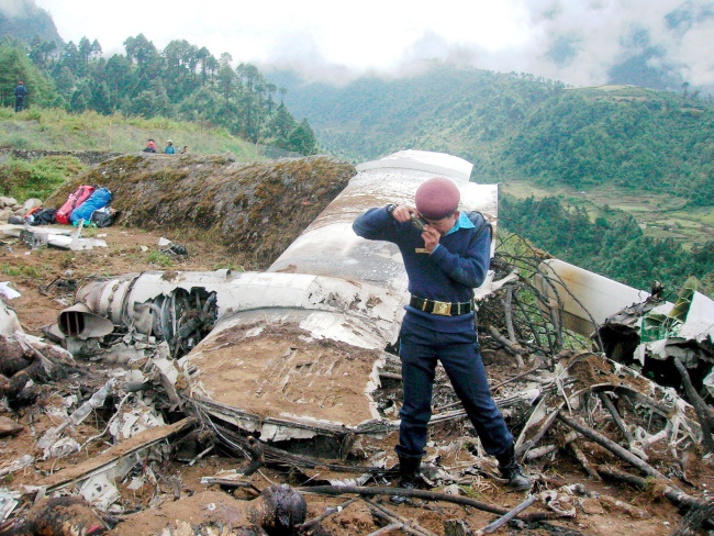 Un policía fotografía los restos de un avión de Yeti Airlines que se estrelló cerca del aeropuerto de la remota localidad de Lukla, en Nepal. (EFE)