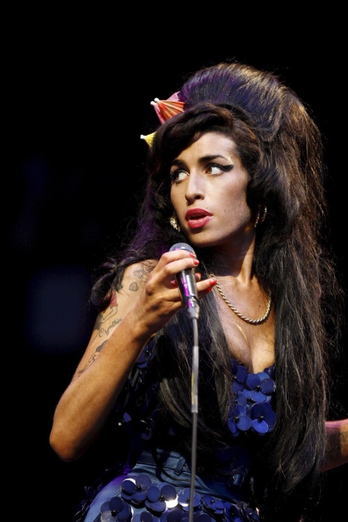 Winehouse lanza golpes a los fotógrafos que la esperaban a las afueras de su casa. 