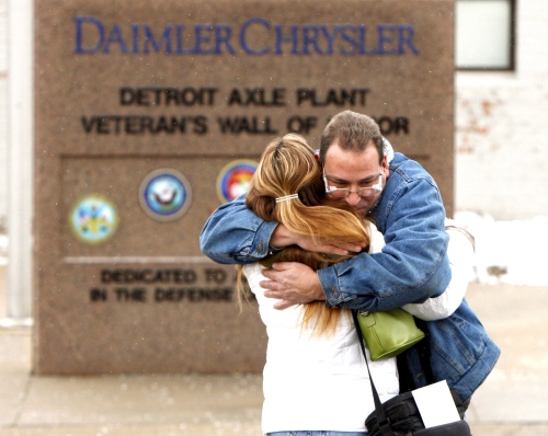 La empleada de Chrysler Cindy Spisak (i) recibe un abrazo de Douglas Yandura luego de cumplir su último turno tras ser despedida de la empresa hoy, 12 de diciembre de 2008, en la planta Axle de Detroit, Michigan, EU.