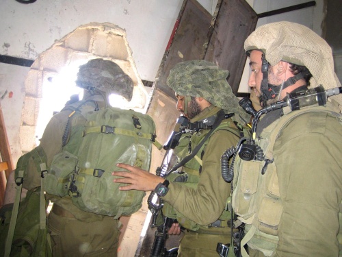 Soldados israelíes avanzan a través de un agujero de un edificio palestino durante la operación contra militantes de Hamas en la Franja de Gaza. Al cumplirse trece días de la ofensiva, Israel ha intensificado los asaltos terrestres a gran escala en Gaza en un esfuerzo por terminar con los ataques contra el Estado judío. (EFE)