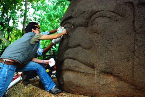 Restauradores del Instituto Nacional de Antropología e Historia (INAH) trabajan en la cabeza monumental olmeca llamada 'La Cabeza del Guerrero', expuesta en el Parque Museo La Venta que se encuentra en Villahermosa, capital del estado mexicano de Tabasco. (Notimex)