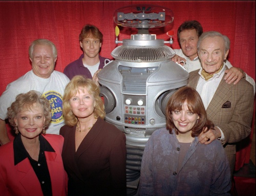 Bob May, a la izquierda del robot, interpretaba al leal compañero de la familia Robinson en la serie “Perdidos en el Espacio”, quien les advertía sobre cualquier emergencia o eventual desastre. (AP)