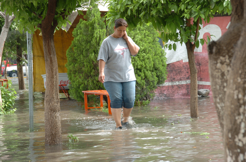 Cuidado. Con precaución camina una mujer por la colonia Provitec. En Vasconcelos y Pavorreal se estancó el agua de la lluvia matutina. 