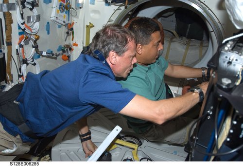 El astronauta de origen mexicano José Hernández, y el de la agencia espacial europea Christer Fuglesan (izquierda), trabajan juntos en el transbordador Discovery durante el segundo día de actividades de la misión a la Estación Espacial Internacional.