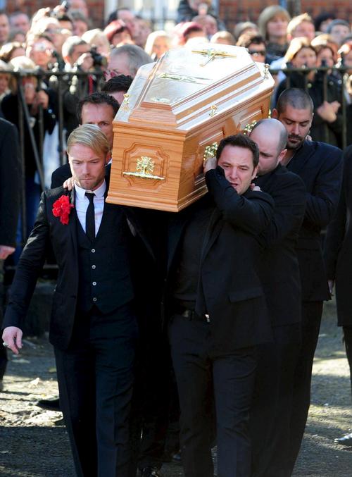Tristeza. Miembros del grupo Boyzone, Ronan Keating (izq.) y Keith Duffy (der.), y familiares de  Stephen Gately, cargaron los restos del músico.  EFE