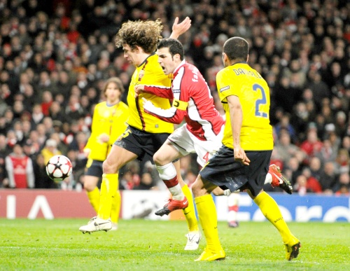 En esta polémica jugada se desarrolló el penal que le dio el empate al Arsenal. Carles Puyol (Izq.) se interpuso entre la pelota y Cesc Fábregas (Cen.) que cayó el césped. (AP)