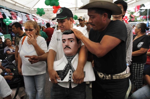 'Gracias Malverde por las bendiciones recibidas', escribieron en notas personas que acudieron al pequeño cuarto tapizado con fotografías, veladoras encendidas y flores frescas. (EFE)