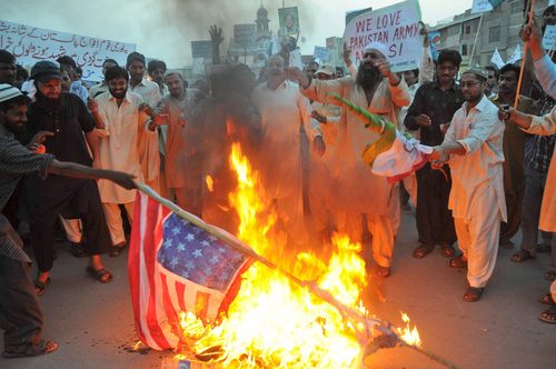 Sí pero no. La secretaria de Estado estadounidense, Hillary Clinton, asegura que Bin Laden tenía apoyo en Pakistán, pero no del Gobierno. En la fotografía del foco aparece un grupo de personas quemando la bandera estadounidense en Pakistán.