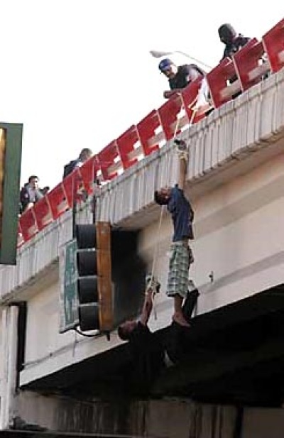 Rescatistas retiraron a un hombre con vida y a otro muerto, que habían sido colgados de las manos en un puente en Monterrey.