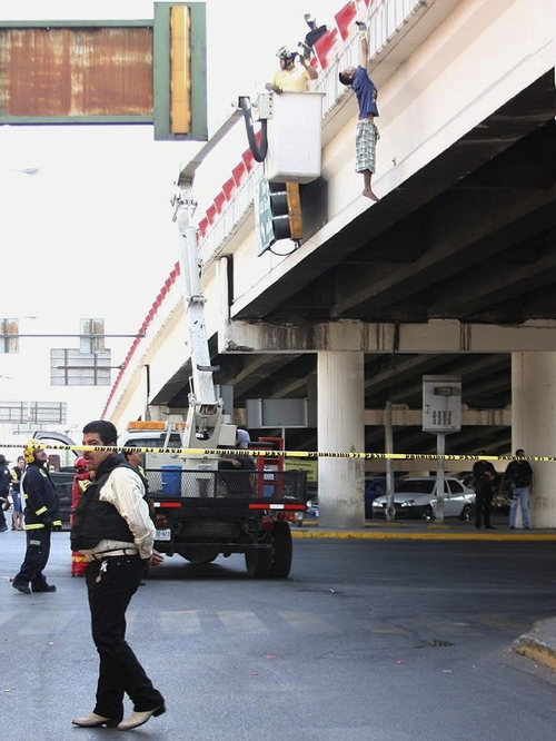 Rescate. Bomberos y rescatistas de Protección Civil auxilian al hombre que fue colgado vivo. 