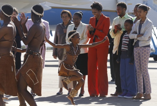 Michell Obama se reunió con un grupo de niños que llevaban en manos banderas de Estados Unidos y de de Bostwana, antes de trasladarse a la clínica para niños con VIH (Virus de Inmunodeficiencia Humana).