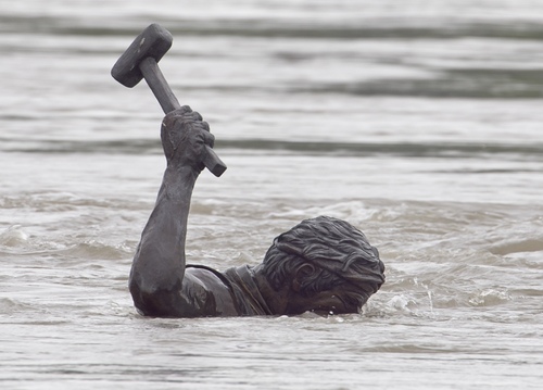 Lluvia. Una estatua a punto de ser cubiera por el agua.