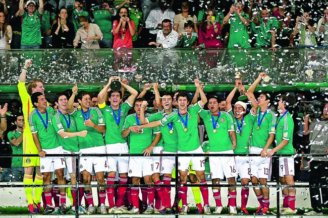 Anotnio “Pollo” Briseño levanta el trofeo de campeón del Mundial Sub-17, mientras sus compañeros celebran el título obtenido ayer en el Estadio Azteca. (Jam Media)