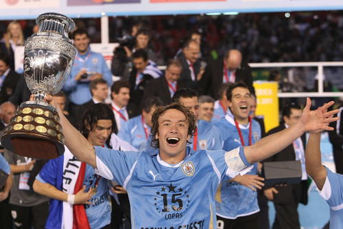 El capitán uruguayo Diego Lugano levanta el trofeo que los acredita como campeones de la Copa América. 