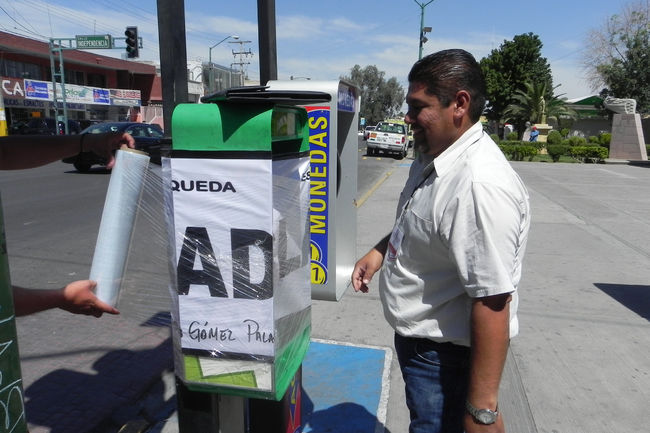 Clausurados. Empleados de Ejecución Fiscal, al momento de clausurar los aparatos de monedas.