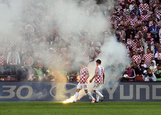 Dos jugadores croatas observan una bengala lanzada al terreno de juego durante el partido del Grupo C de la Eurocopa 2012 disputado entre Italia y Croacia en Poznan, Polonia, el 14 de junio del 2012. (EFE)