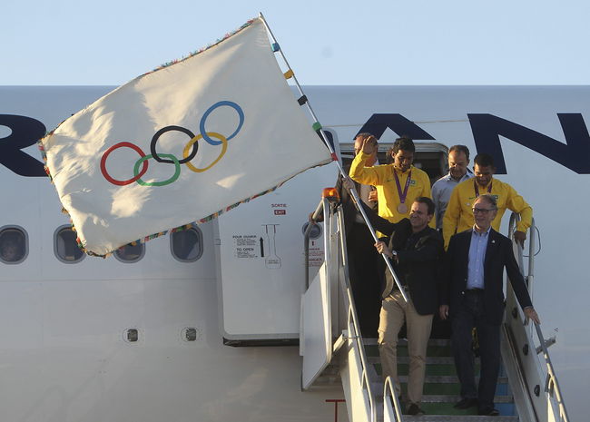 El alcalde de Río de Janeiro, Eduardo Paes, sostiene la bandera de las Olimpiadas a su llegada (a Brasil), procedente de Londres. Aterriza bandera de las Olimpiadas en Río de Janeiro