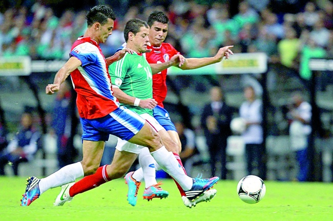 El jugador de México, Javier Hernández (i), lucha por el balón con dos rivales de Costa Rica, durante un partido de la eliminatoria de la Concacaf para el Mundial Brasil 2014 en el Estadio Azteca de Ciudad de México. (Notimex)