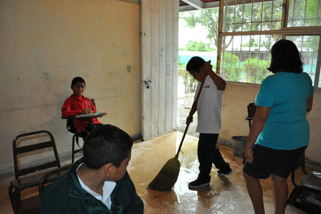 LLuvia. Los alumnos se pusieron a barrer el agua que logró colarse hasta su salón; el problema aparece por ligeras que sean las lluvias.