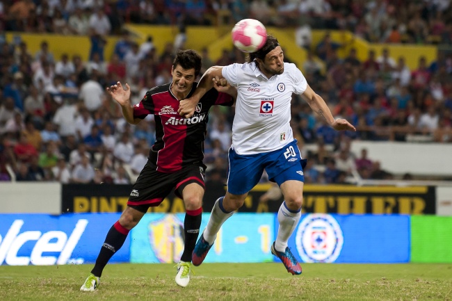 Mariano Pavone cabecea un balón ante la marca de un rival. (Jam Media)