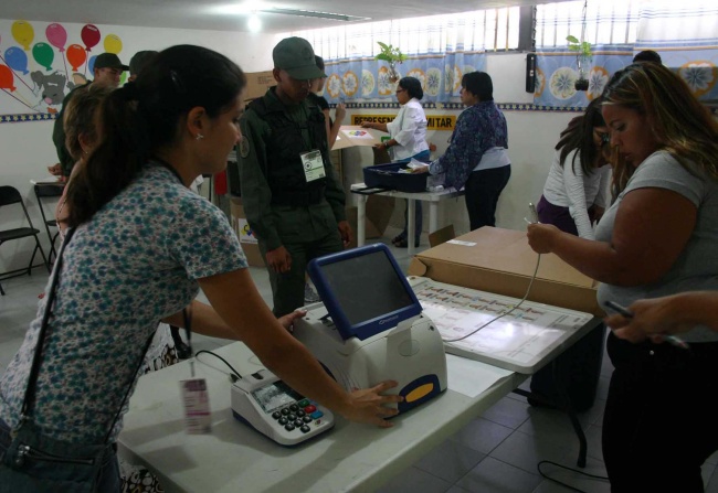 Detalles. Funcionarios electorales de Venezuela alistan las urnas electrónicas y las computadoras para el conteo de votos.