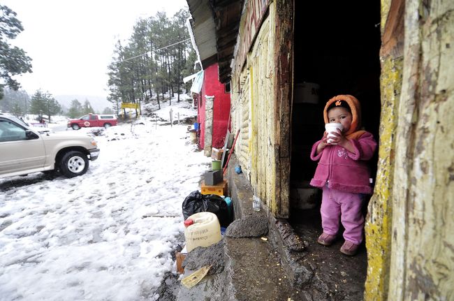 Más frio. Aspectos de la Sierra de Arteaga donde cayó una nevada, se observa a una pequeña tomando un líquido caliente.