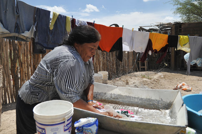 Rezago social.  Una mujer realiza sus labores diarias en la colonia Tanque Aguilereño de Torreón, una zona de alta pobreza.