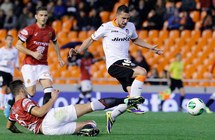 El delantero del Valencia, Paco Alcácer (d), disputa el balón con el defensa del Gimnastic de Tarragona, Pablo Marí Villar (i, en el suelo). (EFE)