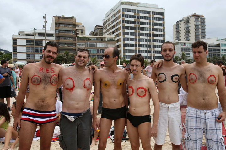 Apoyan a mujeres. Hombres participan en una protesta en la playa de Ipanema.