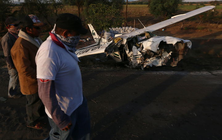 Cae. Miembros de un grupo de autodefensas observan la avioneta accidentada en la que viajaba su líder, Juan Manuel Mireles Valverde. 