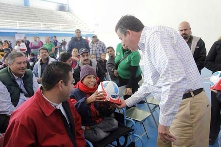 Regalos. El gobernador  aparece entregando balones y muñecos a niños con discapacidad.