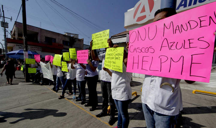 Empleados de farmacia incendiada marchan en Apatzingán