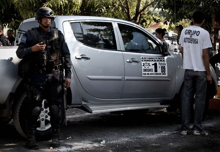 Seguridad. Miembros de autodefensas y elementos de la Policía Federal, estatal y municipal cuidan la entrada del Tianguis del limón ubicado a la entrada de Apatzingán. 