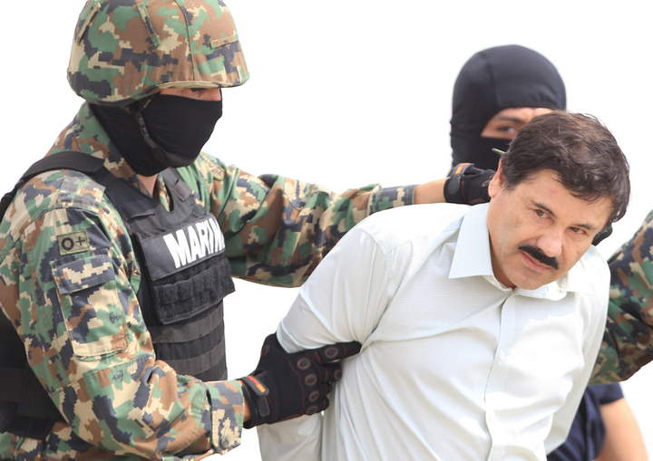 Detenido. Joaquín Guzmán Loera, sometido por un marino, es trasladado hacia un helicóptero en el hangar de la Armada de México.