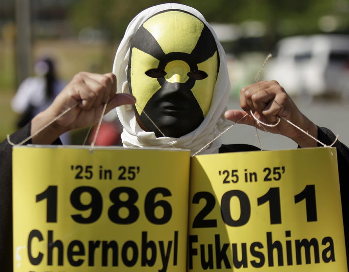 Tragedia nuclear. Un hombre sostiene dos pantacartas donde compara a Fukushima con Chernobyl.