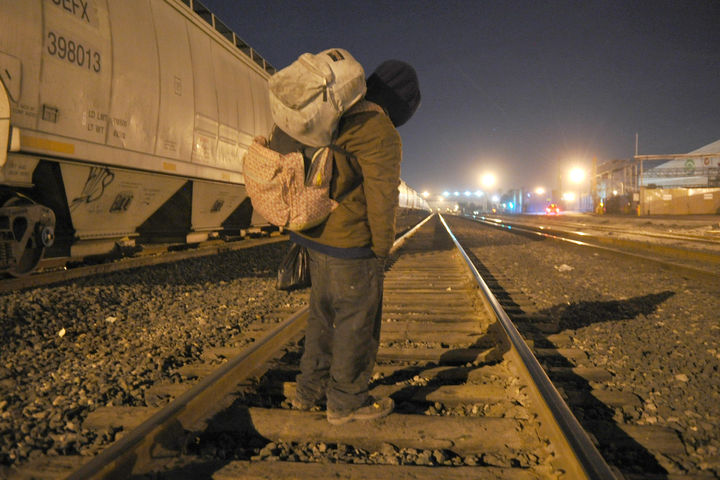 Tren. Un migrante espera la llegada del tren para abordarlo en las vías. 
