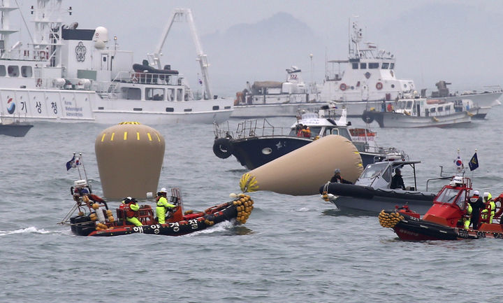 Rescate. Oficiales de la Marina de Corea del Sur trabajan en las boyas para marcar el ferry hundido.