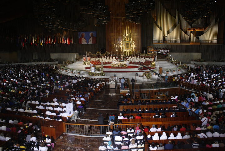 Ceremonia. Creyentes católicos celebran la canonización de los papas Juan Pablo II y Juan XXIII, ayer domingo. 