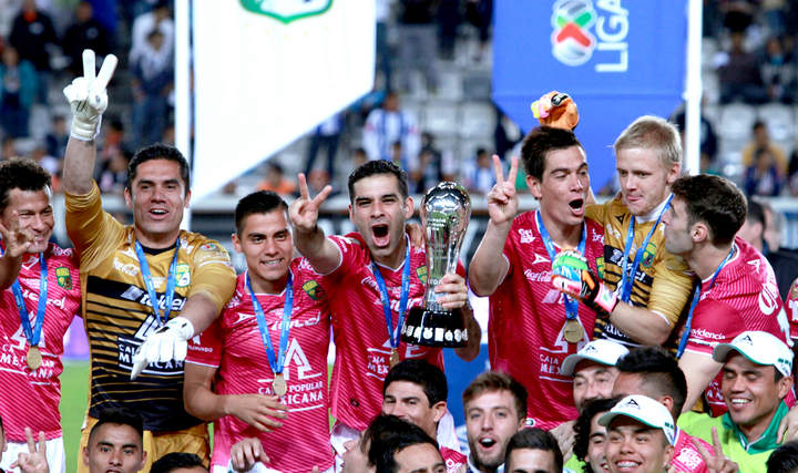 El capitán del León, Rafael Márquez, levanta el trofeo de campeón del Clausura 2014 mientras sus compañeros festejan levantando dos dedos en alusión al bicampeonato obtenido por el equipo. (Jam Media)