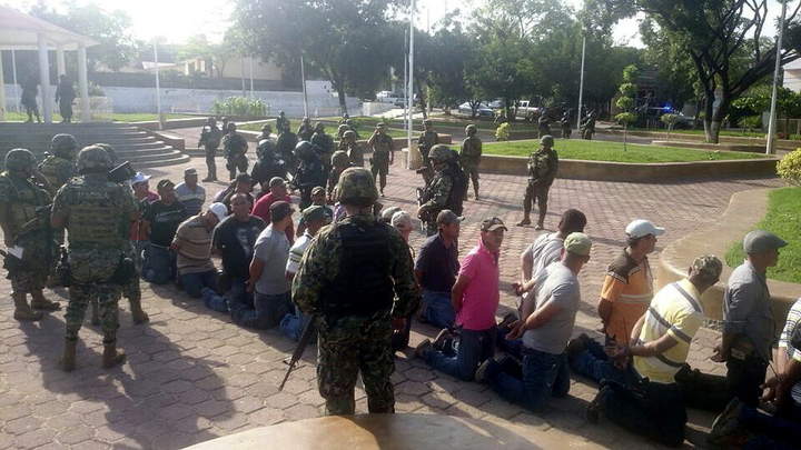 Acción.  Grupo de civiles armados vigilado por soldados de la Marina, Ejército y fuerzas federales tras ser detenidos junto a José Manuel Mireles, uno de los líderes de las autodefensas. 