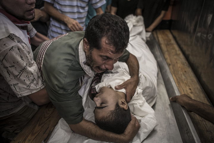 Tragedia. Un padre llora junto al cuerpo de su hijo, que fue asesinado en el bombardeo israelí a la escuela de Beit Hanún. (EFE)