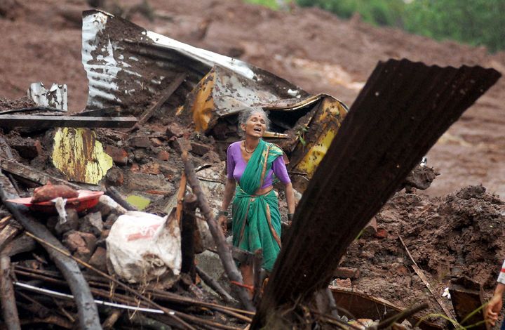 En la India. Una mujer en vano trata de rescatar a miembros de su familia que quedaron atrapados en un alud generado por las lluvias. (AP)