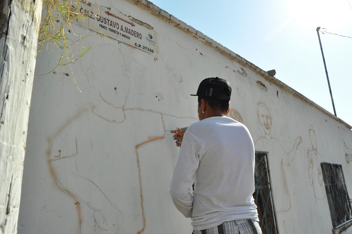 A color. Luego de que Israel realizara las imágenes a lápiz, uno de los jóvenes se encargó de dar color al primer mural contra la violencia. 
