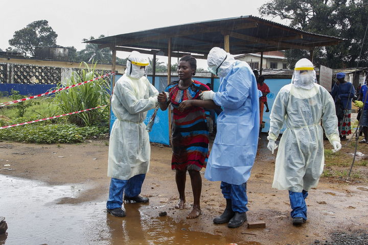 Tratamiento. Unos enfermeros liberianos escoltan a una mujer supuestamente infectada de ébola. (AP)