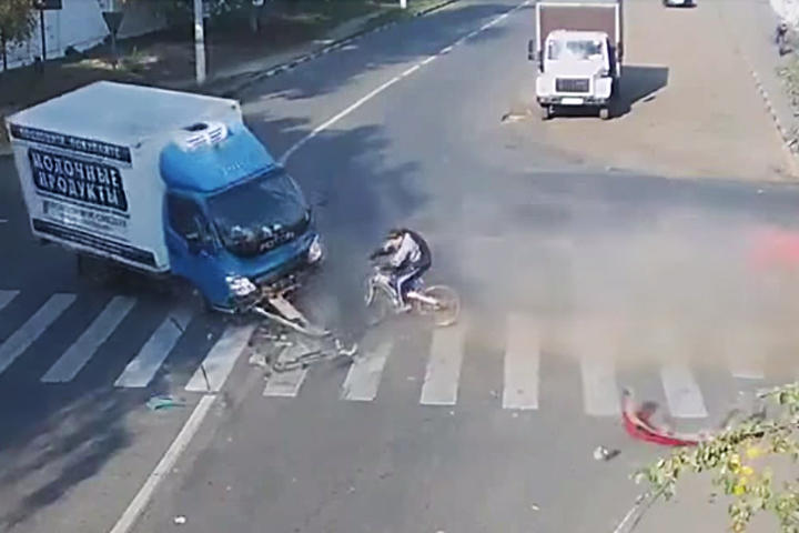 El ciclista sale ileso del accidente, aunque el camión si alcanza a tocarlo. (YouTube)