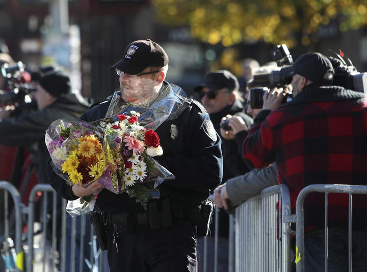 En alerta. Un policía se dispone a colocar flores en el altar de ofrendas por el soldado asesinado. (EFE)