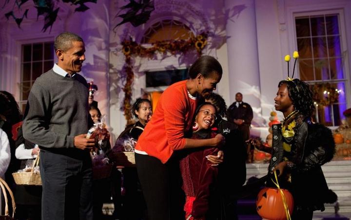 Desde la puerta principal de la Casa Blanca la pareja presidencial entregó dulces a niños de la localidad e hijos de familias de militares. (Twitter) 