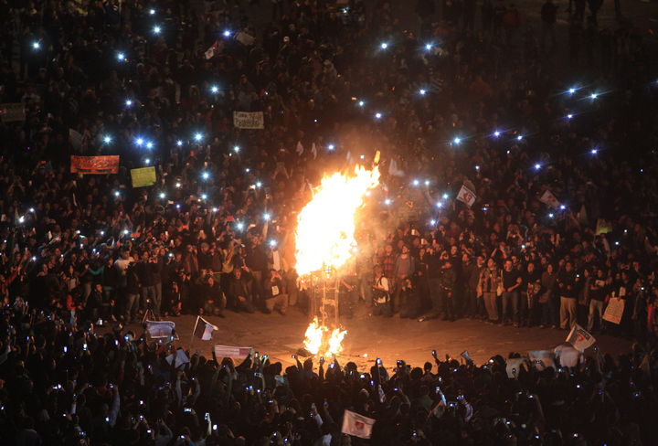 Unidos. Un mar de gente observa cómo una figura de papel de Enrique Peña Nieto arde en el centro del Zócalo.