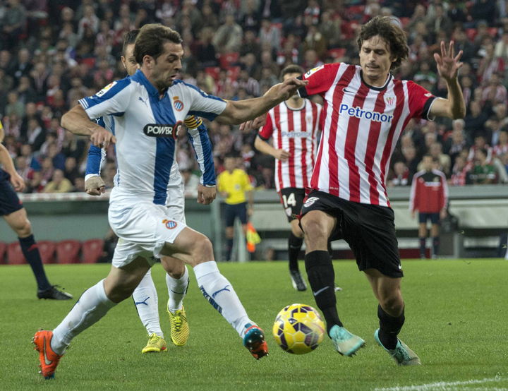 El centrocampista del Espanyol, Víctor Sánchez (i), y el del Athletic, Ander Iturraspe (d), luchan por el balón durante el partido en San Mamés. 